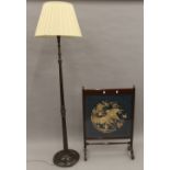 A tapestry inset fire screen and a standard lamp. The former 63.5 cm wide.