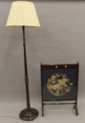 A tapestry inset fire screen and a standard lamp. The former 63.5 cm wide.
