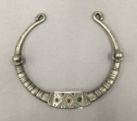 An antique Afghan white metal torc, tooled with glass coloured beads.
