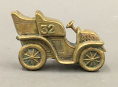 A brass vesta formed as a vintage car. 6.5 cm wide.