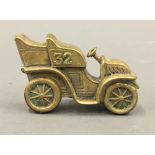 A brass vesta formed as a vintage car. 6.5 cm wide.