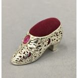 A silver pin cushion formed as a shoe