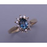 A 9 ct gold blue topaz and diamond cluster ring. Ring size L. 2 grammes total weight.