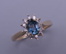 A 9 ct gold blue topaz and diamond cluster ring. Ring size L. 2 grammes total weight.