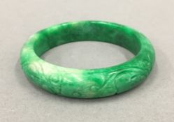 A Chinese carved jade bangle. 7.5 cm diameter.