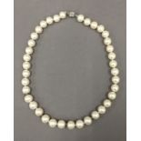 A pearl necklace with diamond set spacers. 43 cm long.