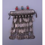 An Afghan white metal amulet with three glass stones. 9 cm long.