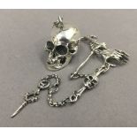 A watch chain set with skull fob. The skull 4 cm long.