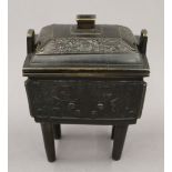 A 19th century Chinese bronze censer and cover on four legs,