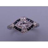 An Art Deco style platinum marquise cut diamond and sapphire ring. Ring size M. 4.