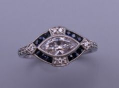 An Art Deco style platinum marquise cut diamond and sapphire ring. Ring size M. 4.