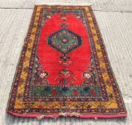 A Persian red ground rug. 91 x 44.5 cm.