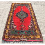 A Persian red ground rug. 91 x 44.5 cm.