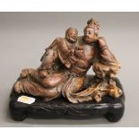 A Chinese soapstone carving on a wooden base. 13 cm high.