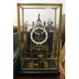 A brass skeleton clock, under glass case. 54 cm high overall, 33.5 cm wide, 23.5 cm deep.