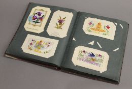 A vintage postcard album, containing various WWI silk and other postcards.
