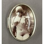 A silver oval pill box depicting a nude.