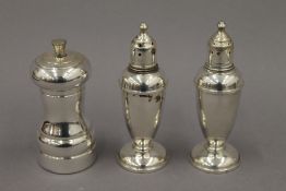 A sterling silver peppermill and a pair of weighted sterling silver salt and pepper pots. 14.