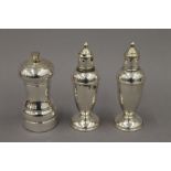 A sterling silver peppermill and a pair of weighted sterling silver salt and pepper pots. 14.