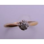 An 18 ct gold and platinum diamond solitaire ring. Ring size M. 2.3 grammes total weight.