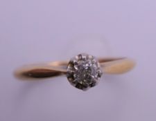 An 18 ct gold and platinum diamond solitaire ring. Ring size M. 2.3 grammes total weight.