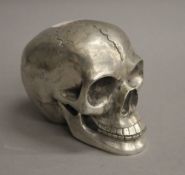 A plated model of a skull. 9 cm high.