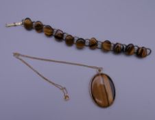 A tigers eye pendant on a 9 ct gold chain and a tigers eye bracelet. The latter 17 cm long.