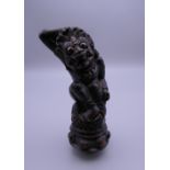 An Indonesian carved wooden kris handle formed as Rangha. 11.5 cm high.