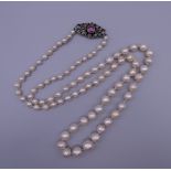 A vintage freshwater pearl necklace with an unmarked gold, diamond and ruby clasp. 67 cm long.