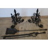 Pair of wrought metal fire dogs and a three piece steel fire companion set