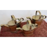 Set of three graduating oval bodied copper watering cans, with ribbed detail