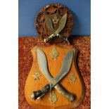 Carved wood wall plaque mounted with two Kukri type knives with a crowned Staffordshire Gurkha