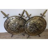 Pair of decorative embossed brass shields and sword wall plaque (diameter 56cm)