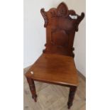 Late Victorian walnut hall chair with carved decoration on turned tapering ring legs