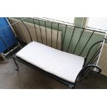 Wrought metal two seat bench with later added loose swab cushion (width 137cm)