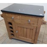 A light wood marble topped rectangular kitchen island with various drawers, cupboards and wine