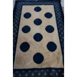 20th C blue ground oriental patterned rug with central beige patterned border set with blue rounders