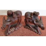 Pair of Chinese carved hard wood figures riding water buffalo with inset glass eyes (height 17cm)