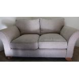 Modern two seat sofa in oatmeal type upholstery on light wood supports (width 160cm)