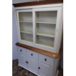 Modern pine and cream painted dresser with two glazed sliding doors above three paneled cupboard