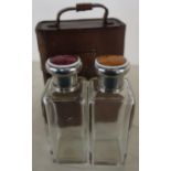 c.1920's tan leather cased pair of travelling glass square form scent bottles with white metal and