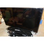 Samsung 55 inch flat screen TV with three tier smoke glass stand, associated DVD player, surround