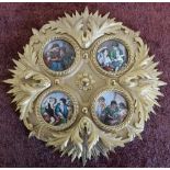 Circular gilt wall plaque inset with four porcelain panels depicting various figures (diameter 28cm)