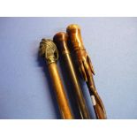 Collection of three Edwardian and later walking canes, one with cast metal head, another with the
