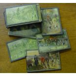 Set of fourteen coloured postcards of fox hunting scenes, mounted behind glass