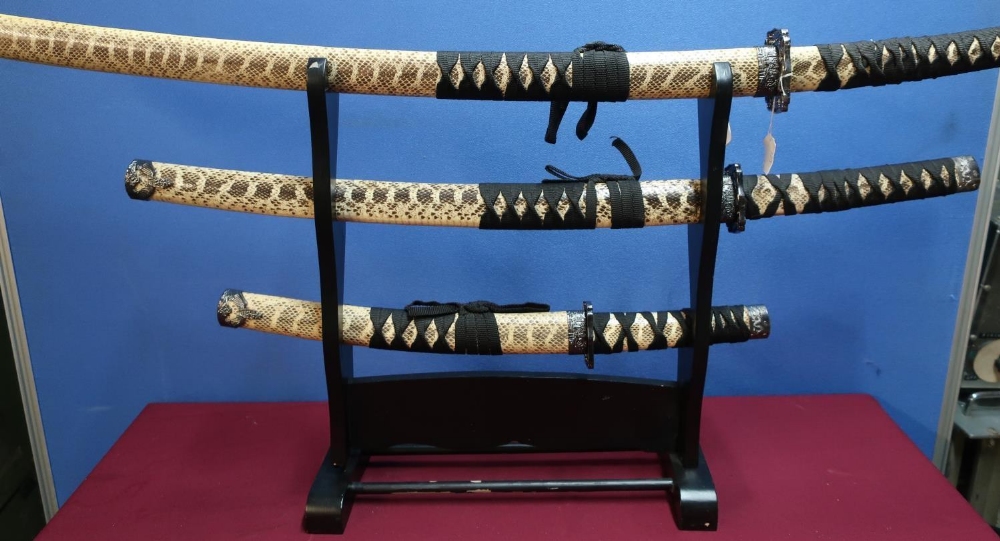 Set of three decorative Japanese style samurai swords with stand