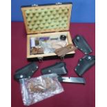 Wooden box containing a selection of various pistol grips, including checkered wooden grips for