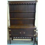 Oak dresser with two tier raised back and two panelled cupboard doors to the base, with brass lock