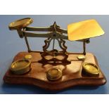 Set of brass postage scales mounted on mahogany plinth stamped 'Warranted Accuracy' with a small