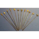 Set of twelve meat skewers, the gilt metal tops with various crests, Roman style figures etc